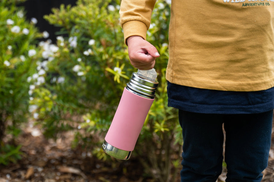 CaliWoods kid's water bottle held in a little boy's hand on a plant background