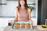 Green Reusable Baking Mat on a tray with cookies and woman smiling