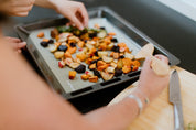 Green Reusable Baking Mat with roast veges on a tray