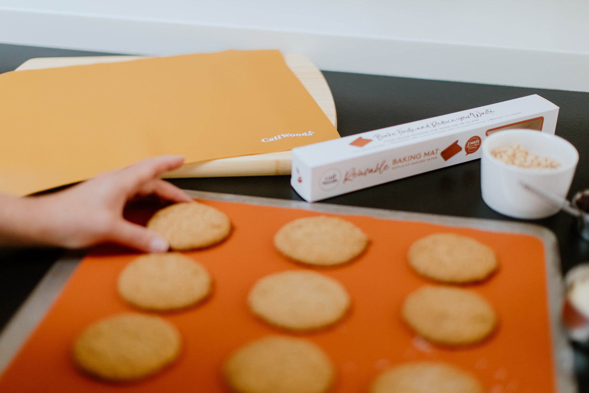 Orange silicone baking mats with cookies on top