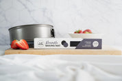 Circular silicone cake tin liners styled with strawberries and a cake tin