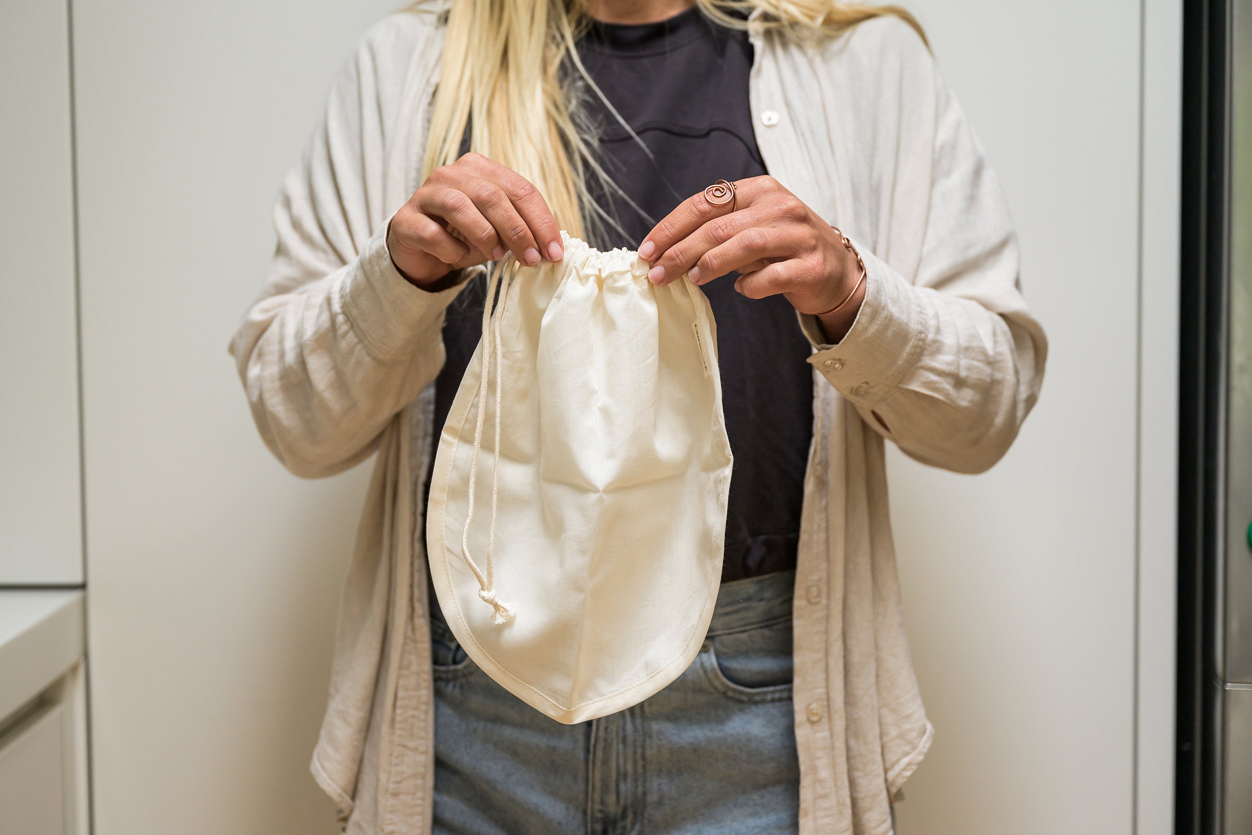 Woman holding a CaliWoods Nut Milk bag with the drawstring pulled closed