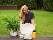 Woman on grass looking down at the CaliWoods Summer eco kit gift bag