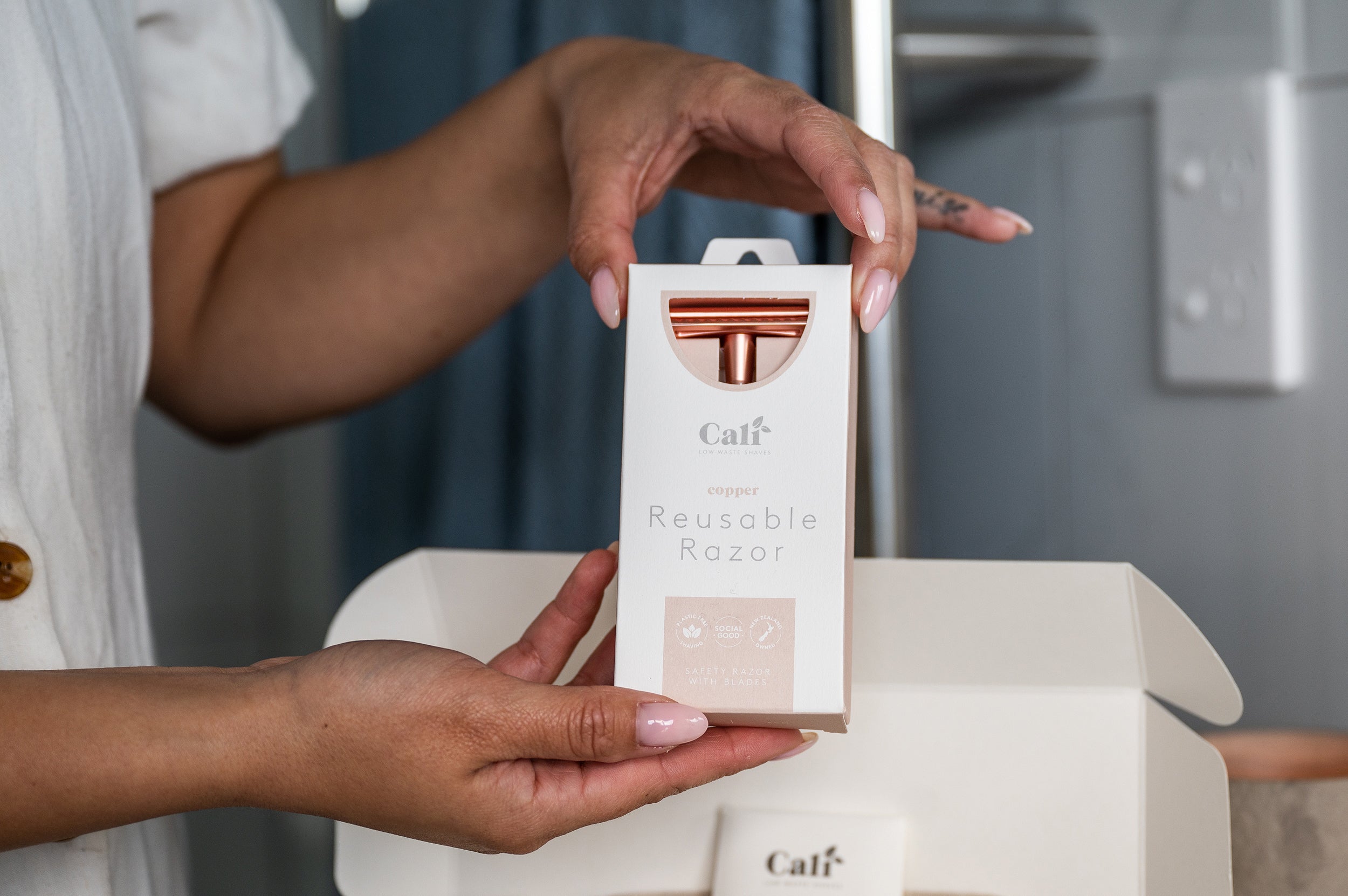 Copper Razor from the CaliWoods Shaving Kit being held by woman's hands