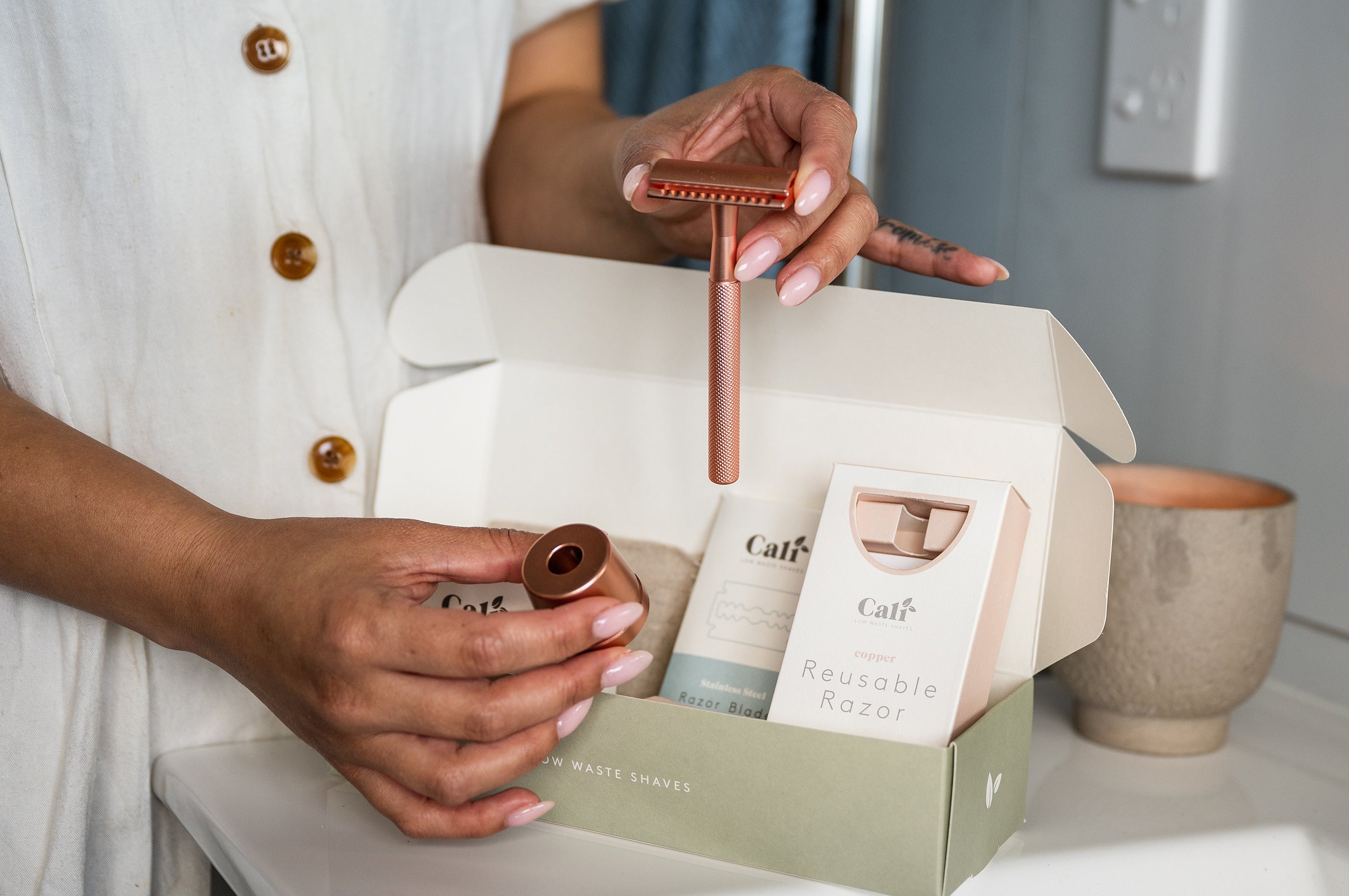 Rose Gold CaliWoods rose gold Safety Razor and Safety Razor stand being held in hand