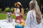 Picnic with dog and two women drinking from CaliWoods insulated water bottles