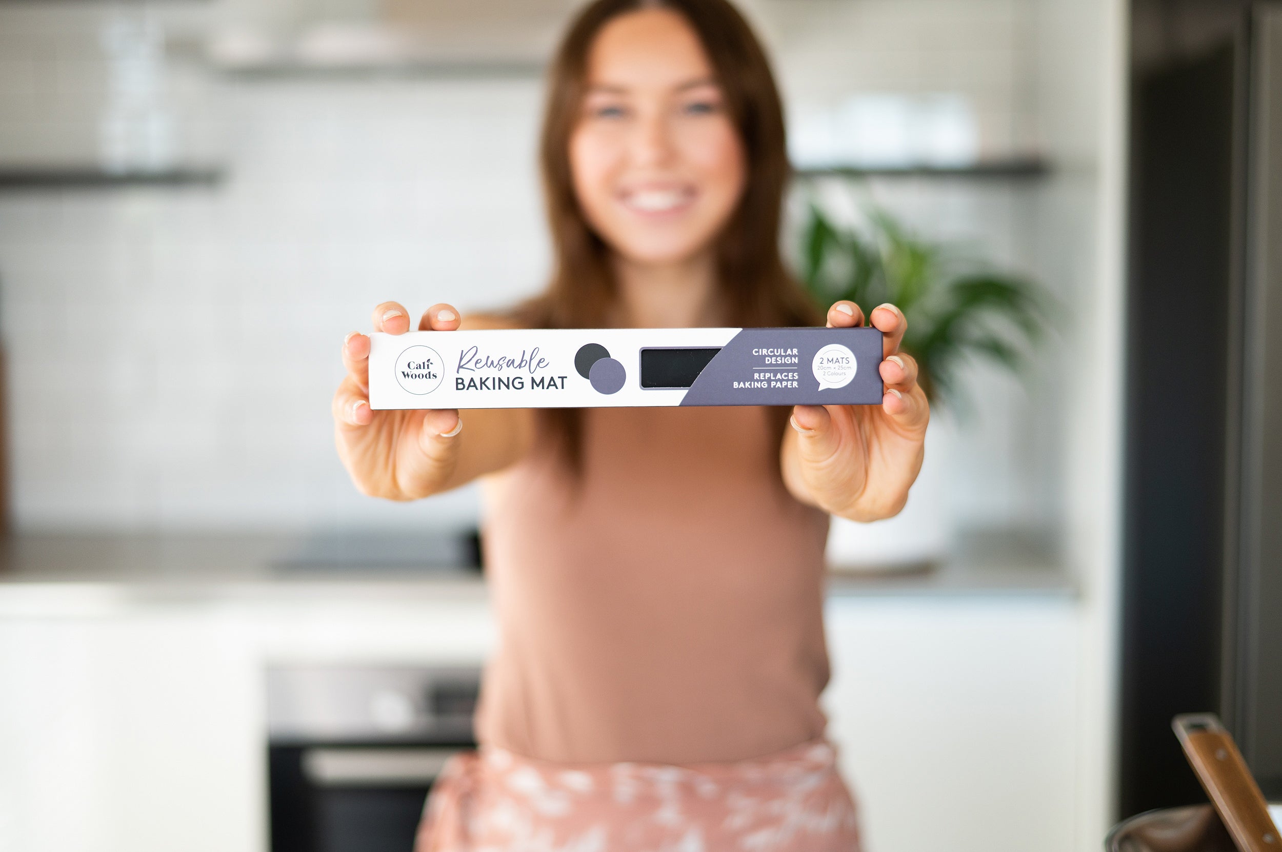 Woman holding out the Cricular Reusable Baking Mat pack