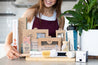 A selection of CaliWoods eco kitchen reusables with woman smiling 