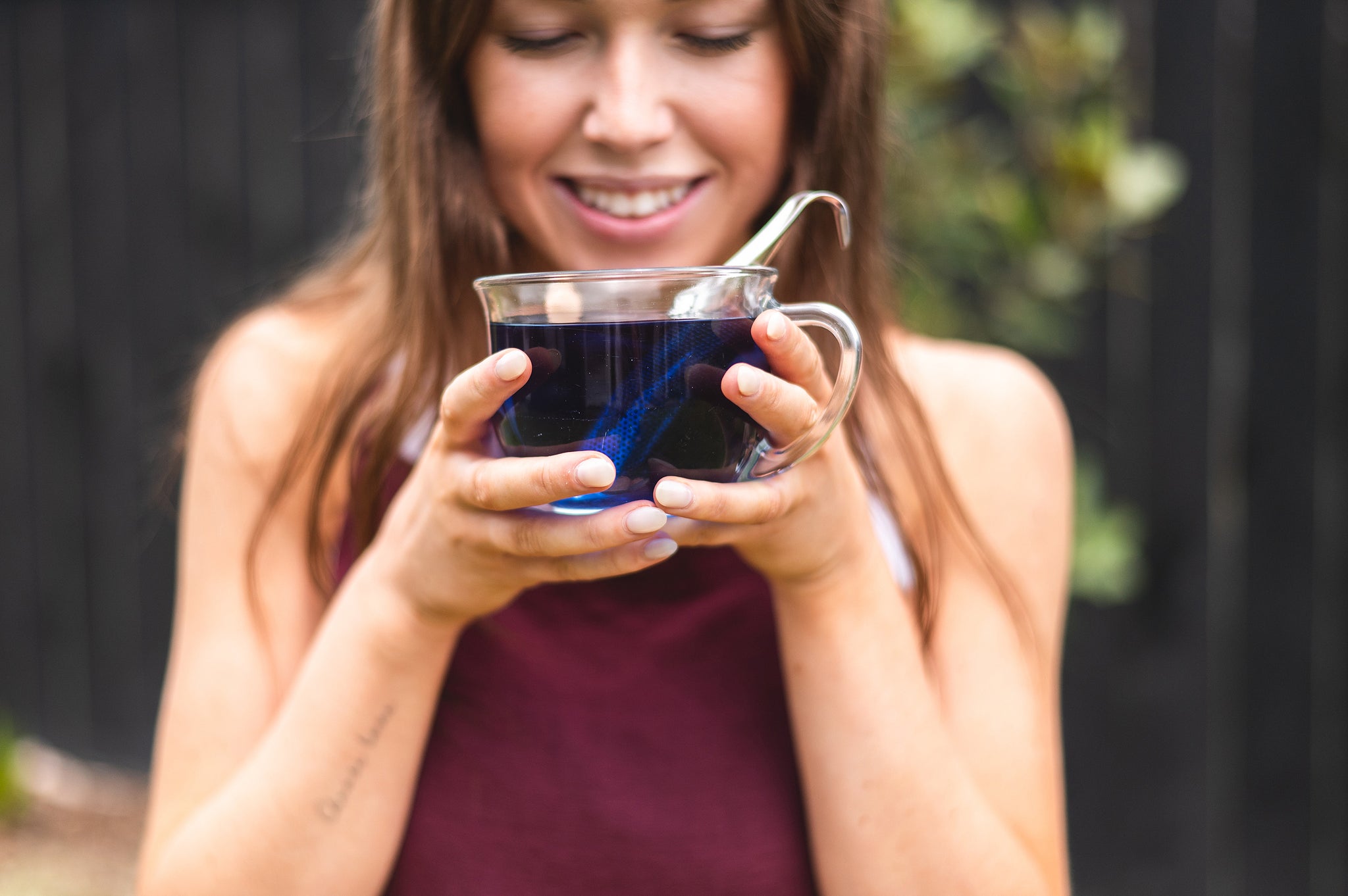 Woman holding a cup of tea with the Tea Infuser in the cup 