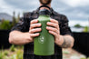 Man holding large deep green CaliWoods insulated cooler drink bottle