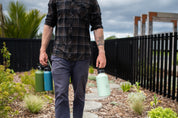 Man walking and holding reusable water bottles by the swing lids