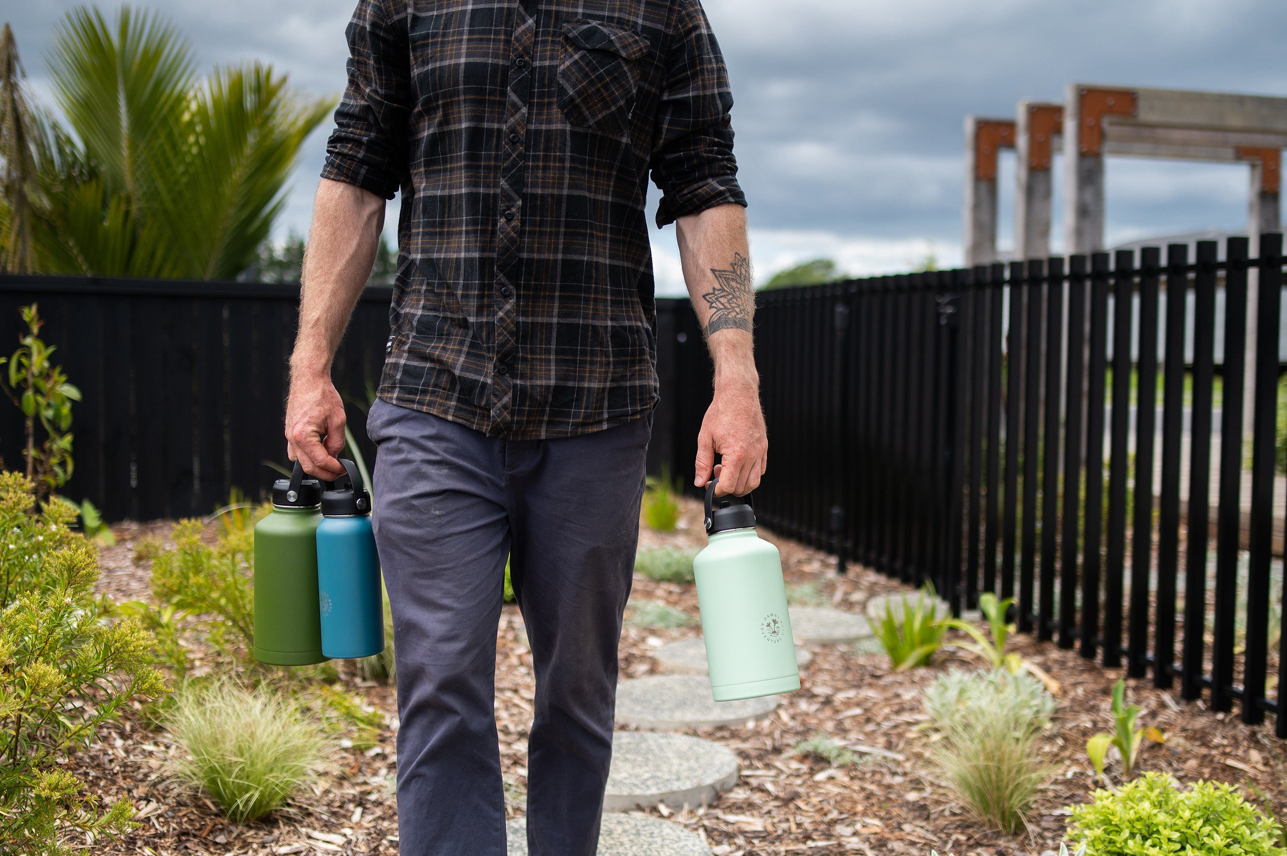 Man walking and holding reusable water bottles by the swing lids