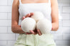 three Dryer Balls held in a woman's hands