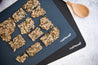 Reusable Baking Mat with crackers on top and a wooden spoon 