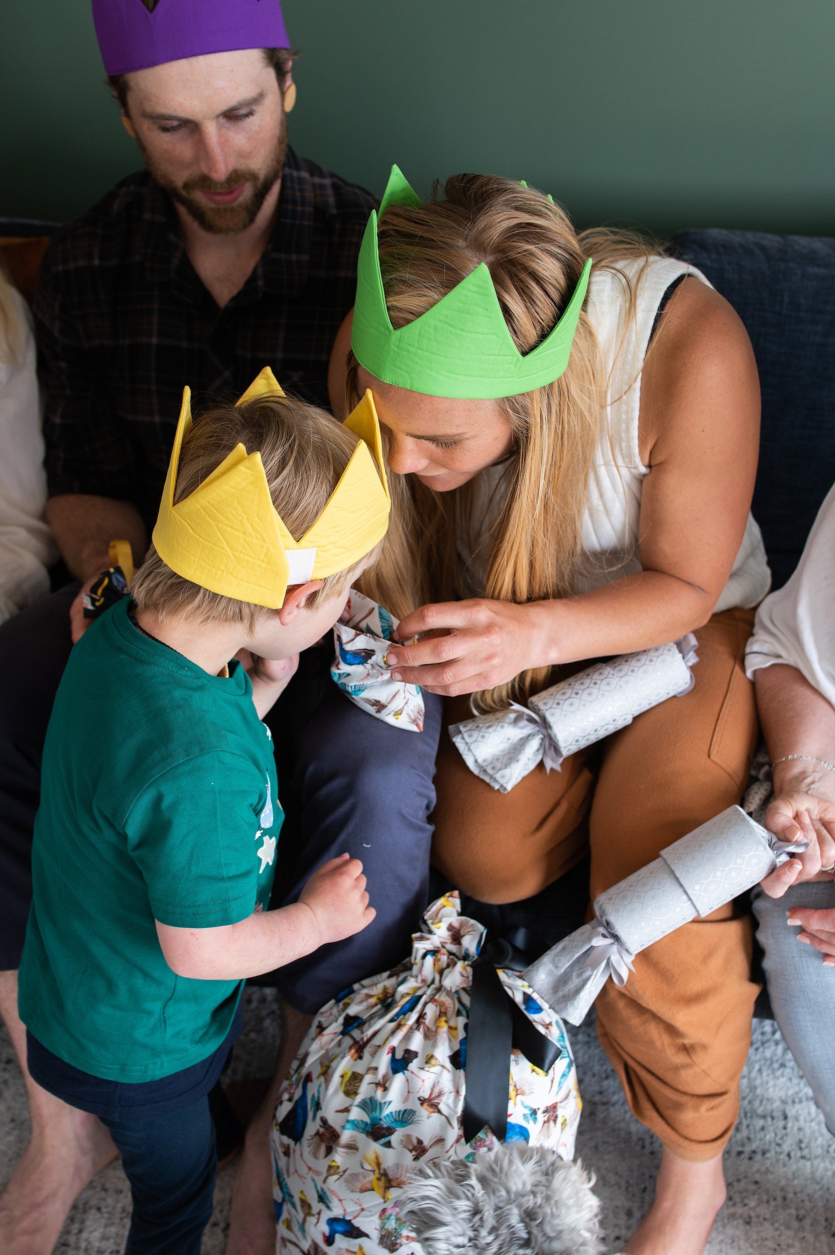 A mother and son look at christmas gifts while wearing caliwoods reusable party hats