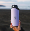 950ML Purple stainless steel water bottle being held in hands on a beach 