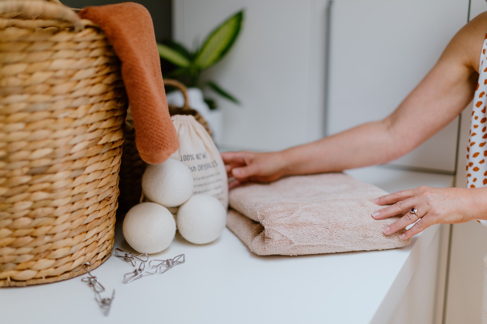 CaliWoods Dryer Balls on a bench with Stainless Steel Pegs and the hands of a woman on a towel